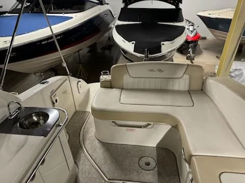 Slide: The Image of 2012 Sea Ray 280 Sundancer interior with seating and kitchenette, docked among other boats. - 16