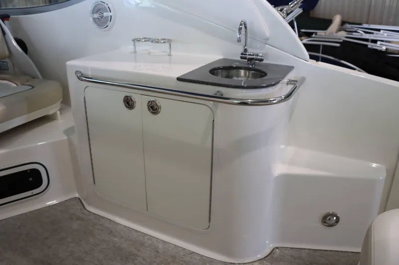 Slide: The Image of 2012 Sea Ray 280 Sundancer boat interior with sink and storage cabinet. - 19