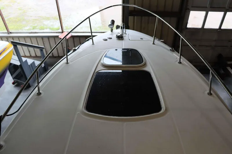 Slide: The Image of 2012 Sea Ray 280 Sundancer boat deck with hatches in a garage. - 24