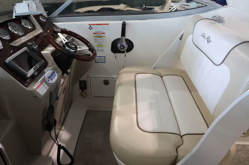 Slide: The Image of Interior of 2012 Sea Ray 280 Sundancer boat with steering wheel and beige seating. - 26