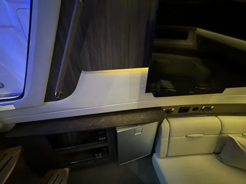 Slide: The Image of Interior of 2020 Sea Ray 400SLX with TV, mini-fridge, and seating area. - 35