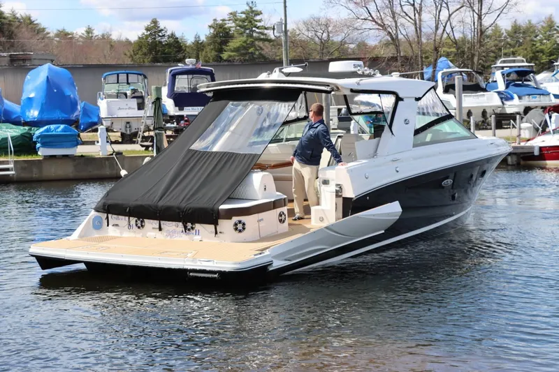 Slide: The Image of 2020 Sea Ray 400SLX luxury boat docked with a person on board. - 6