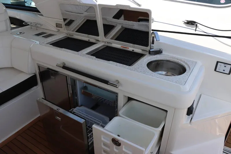 Slide: The Image of Outdoor kitchen on a 2020 Sea Ray 400SLX boat with grill, sink, and storage. - 9