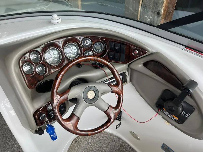 Slide: The Image of 2004 Crownline 270BR boat dashboard with woodgrain steering wheel and instrument panel. - 5