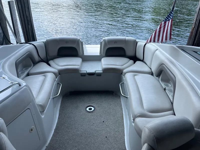 Slide: The Image of 2004 Crownline 270BR boat interior with spacious seating and American flag. - 8