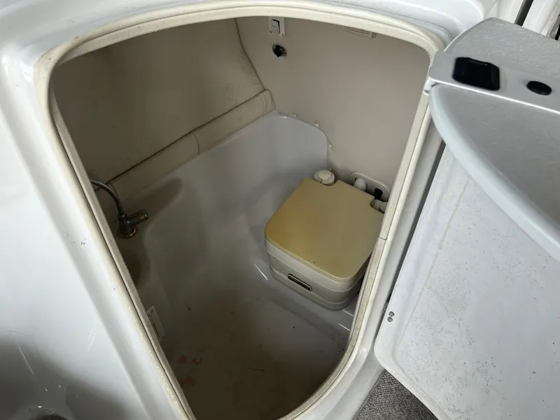 Slide: The Image of 2004 Crownline 270BR boat interior with compact toilet and sink. - 9