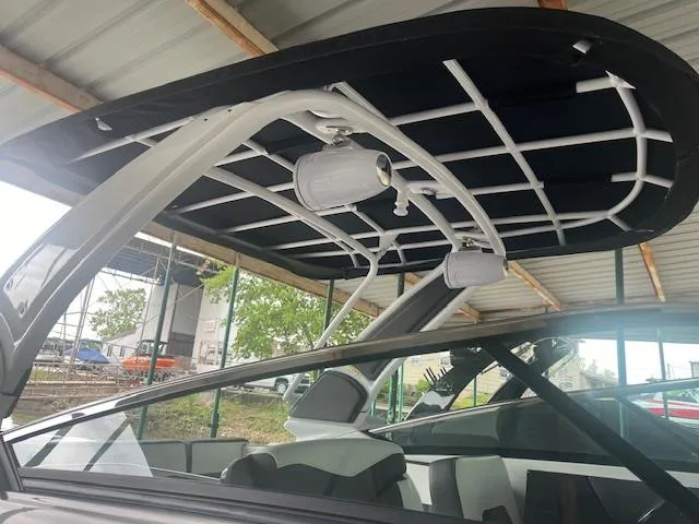 Slide: The Image of 2022 Monterey 298 Super Sport boat with black canopy and speakers. - 2