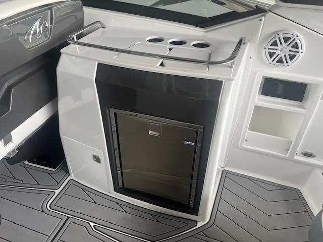 Slide: The Image of 2022 Monterey 298 Super Sport boat interior with mini fridge and storage compartments. - 6
