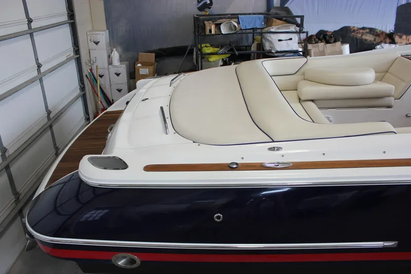 Slide: The Image of 2004 Chris-Craft 28 Launch boat with cream upholstery and sleek design in a garage setting. - 11