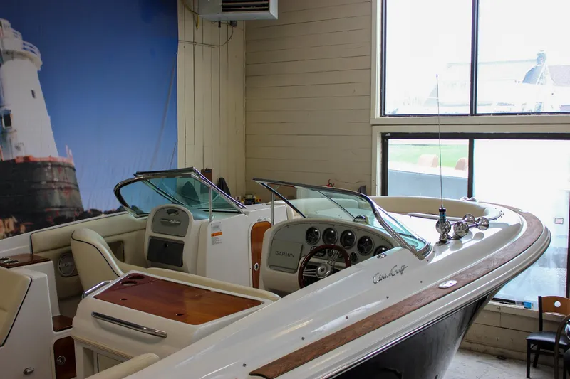 Slide: The Image of 2004 Chris-Craft 28 Launch boat interior with dashboard and seating in showroom. - 12