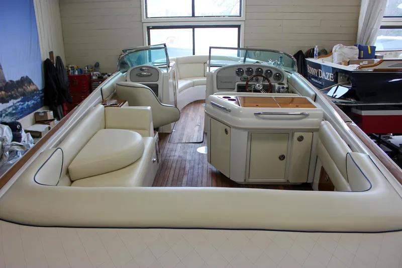 Slide: The Image of 2004 Chris-Craft 28 Launch boat interior with white seating and wooden flooring. - 14