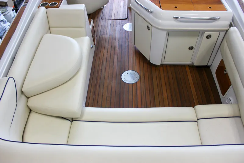 Slide: The Image of 2004 Chris-Craft 28 LAUNCH interior with white leather seating and wooden flooring. - 15