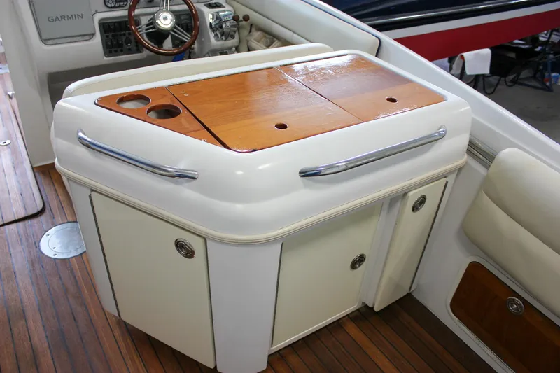 Slide: The Image of 2004 Chris-Craft 28 LAUNCH boat interior with wooden cabinetry and steering wheel. - 16