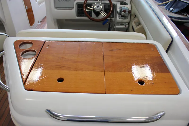 Slide: The Image of 2004 Chris-Craft 28 LAUNCH boat interior with wooden table and steering wheel. - 17