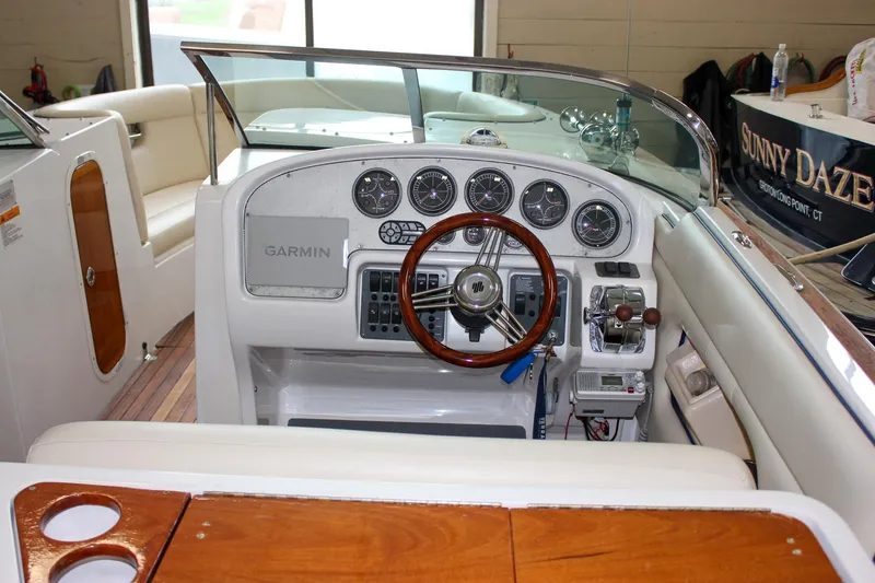 Slide: The Image of 2004 Chris-Craft 28 Launch boat interior with steering wheel and dashboard controls. - 18