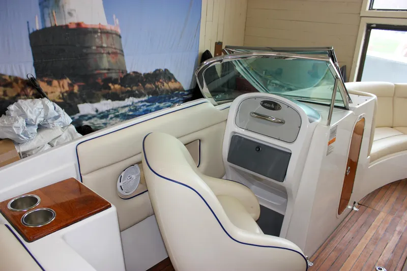 Slide: The Image of 2004 Chris-Craft 28 Launch boat interior with beige seating and wooden accents. - 19