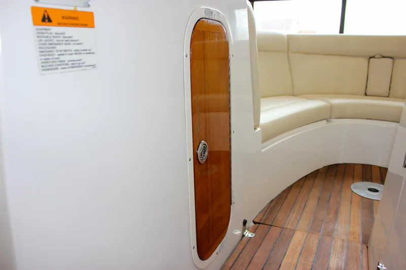 Slide: The Image of Interior of 2004 Chris-Craft 28 Launch boat with wooden door and cushioned seating. - 23