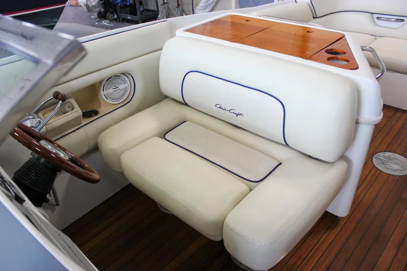 Slide: The Image of 2004 Chris-Craft 28 Launch boat interior with white leather seating and wooden accents. - 26