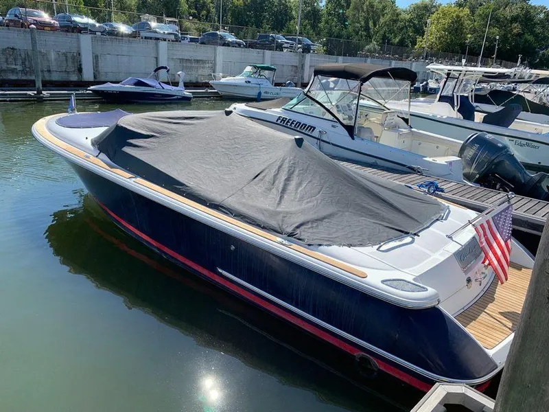 Slide: The Image of 2004 Chris-Craft 28 LAUNCH boat docked with cover, American flag at stern. - 4