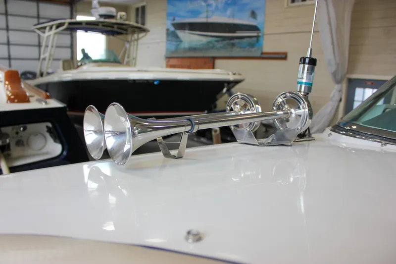 Slide: The Image of 2004 Chris-Craft 28 LAUNCH boat with chrome horns in a showroom setting. - 40