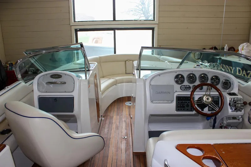 Slide: The Image of 2004 Chris-Craft 28 Launch boat interior with wood accents and steering wheel. - 43