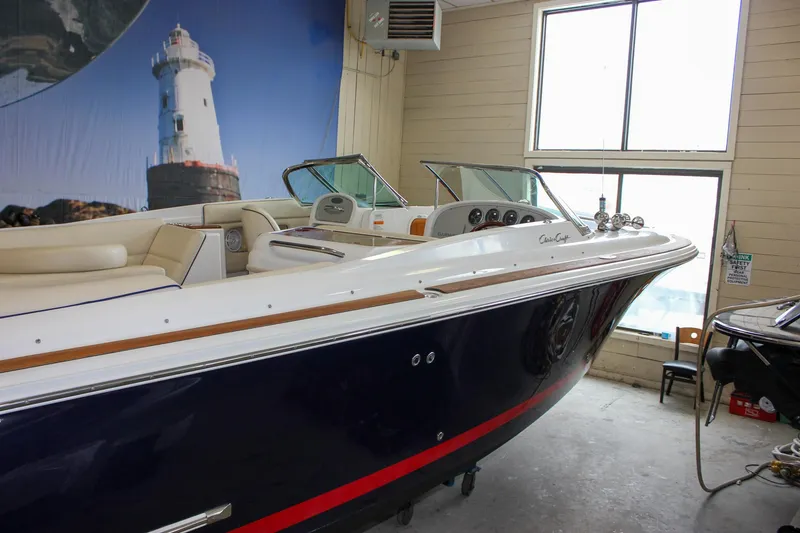 Slide: The Image of 2004 Chris-Craft 28 Launch boat in indoor storage, featuring sleek design and luxurious seating. - 49