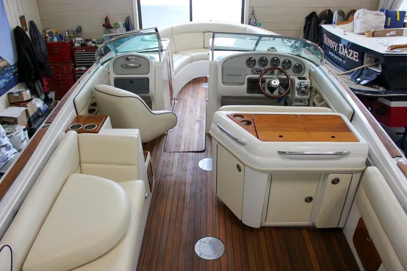 Slide: The Image of 2004 Chris-Craft 28 Launch boat interior with wooden deck and white seating. - 7