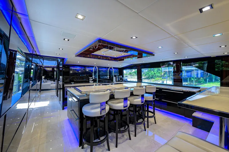 Slide: The Image of Luxurious interior of 1997 Broward 108 Raised Pilothouse yacht with modern bar and seating. - 31