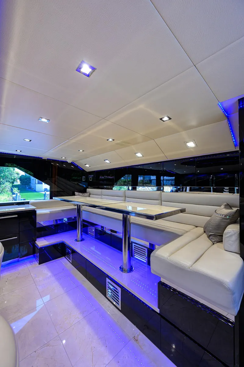 Slide: The Image of Luxurious interior of 1997 Broward 108 Raised Pilothouse yacht with modern seating and blue LED lighting. - 37