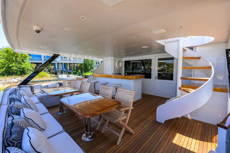 Slide: The Image of Luxurious deck of 1997 Broward 108 Raised Pilothouse yacht with seating and spiral staircase. - 4