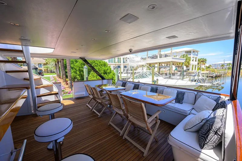 Slide: The Image of Spacious deck of 1997 Broward 108 Raised Pilothouse yacht with seating and dining area. - 7