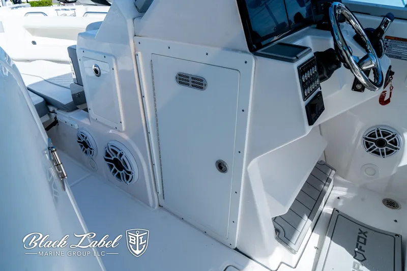 Slide: The Image of 2024 Sea Fox 288 Traveler Dual Console interior with steering wheel and speaker system. - 11