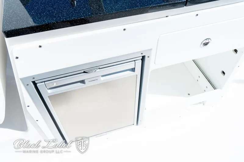 Slide: The Image of 2024 Sea Fox 288 Traveler Dual Console interior with built-in storage and mini fridge. - 25