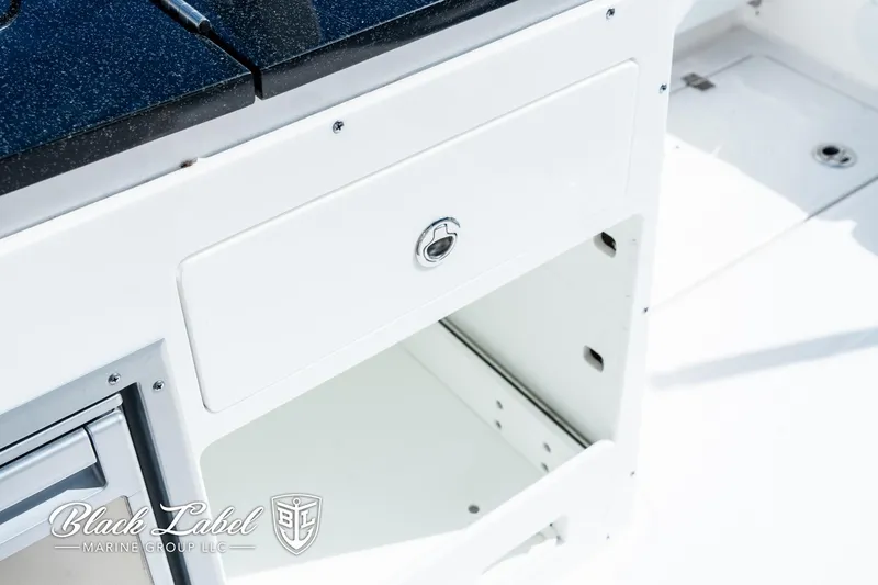 Slide: The Image of 2024 Sea Fox 288 Traveler Dual Console storage compartment, featuring sleek white design and secure latch. - 26