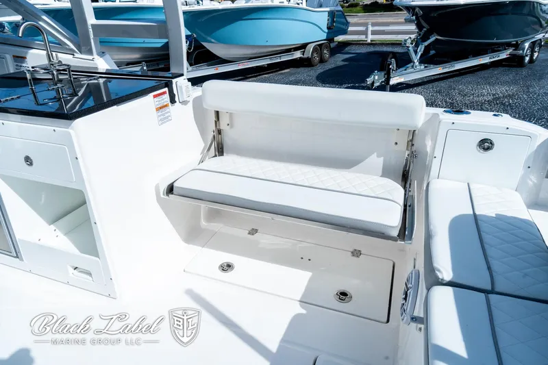 Slide: The Image of 2024 Sea Fox 288 Traveler Dual Console boat interior with white seating and storage. - 35