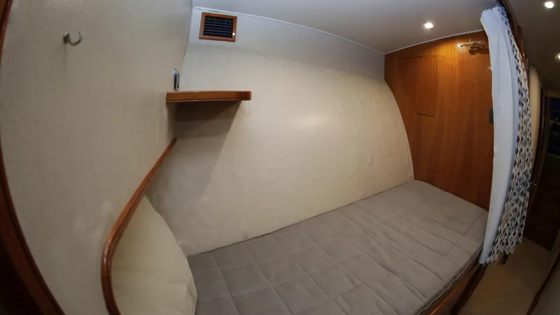 Slide: The Image of Custom Carolina Dean Johnson 2003 boat interior with a single bed and wooden accents. - 38