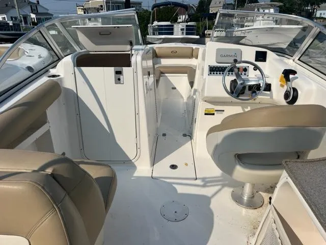 Slide: The Image of 2020 Key West 239 DFS boat interior with beige seating and Garmin navigation system. - 7