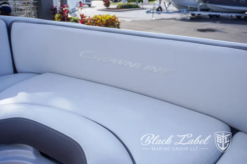 Slide: The Image of 2024 Crownline E260 XS boat interior with white seating, Black Label Marine Group logo. - 16