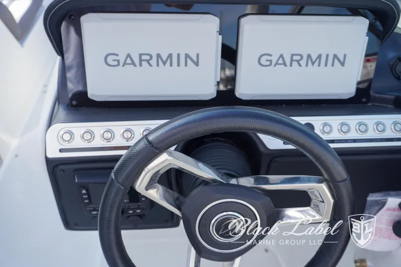Slide: The Image of 2024 Crownline E260 XS dashboard with dual Garmin displays and steering wheel. - 20