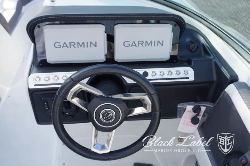 Slide: The Image of 2024 Crownline E260 XS dashboard with dual Garmin displays and steering wheel. - 21