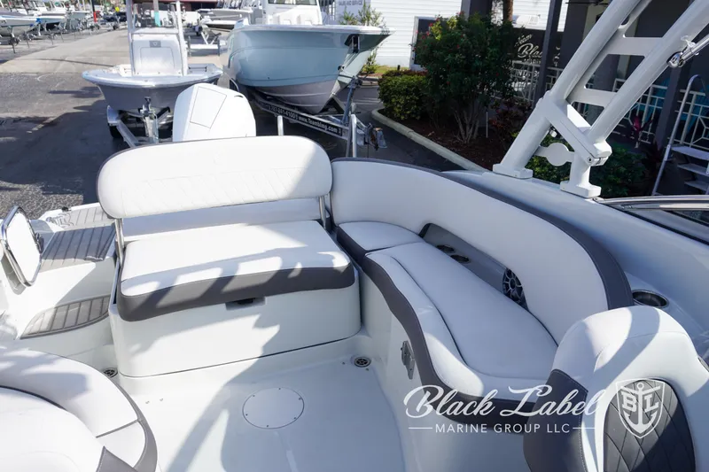 Slide: The Image of 2024 Crownline E260 XS boat interior with white seating, docked at marina. - 25