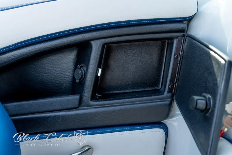 Slide: The Image of 2024 Crownline E260 XS interior storage compartment with sleek black and white design. - 21