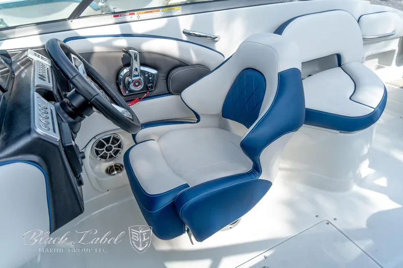 Slide: The Image of 2024 Crownline E260 XS boat interior with blue and white seating and steering wheel. - 22
