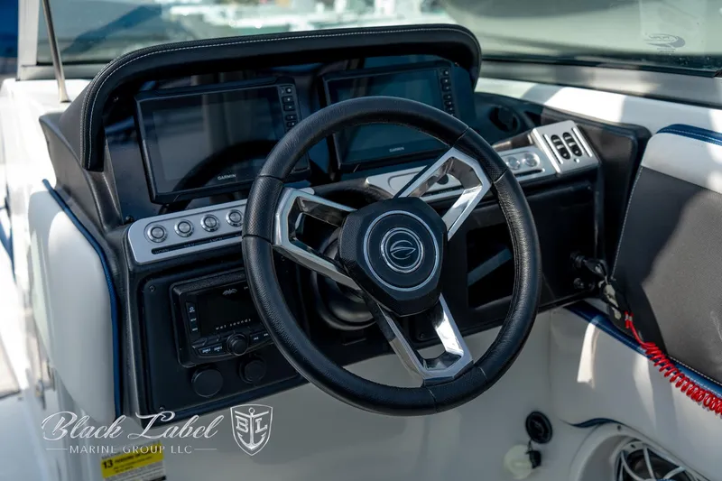 Slide: The Image of 2024 Crownline E260 XS boat dashboard with steering wheel and control panel. - 24