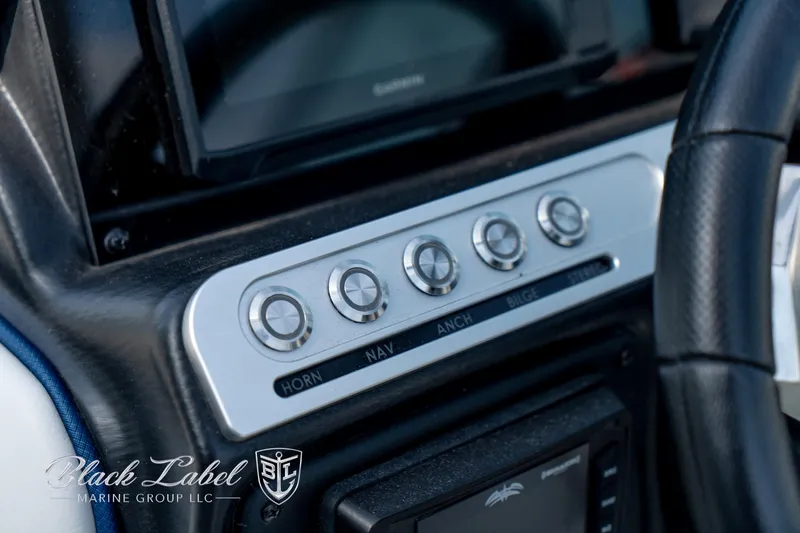 Slide: The Image of 2024 Crownline E260 XS boat dashboard with control buttons and steering wheel. - 25