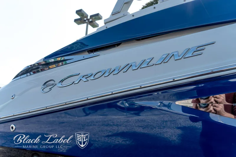 Slide: The Image of 2024 Crownline E260 XS boat, blue exterior, Black Label Marine Group logo visible. - 3