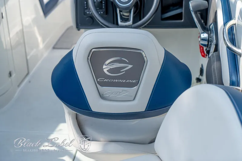 Slide: The Image of 2024 Crownline E260 XS boat seat with logo, featuring blue and white upholstery. - 36