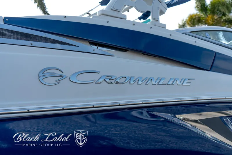 Slide: The Image of 2024 Crownline E260 XS boat with sleek design, Black Label Marine Group logo. - 4