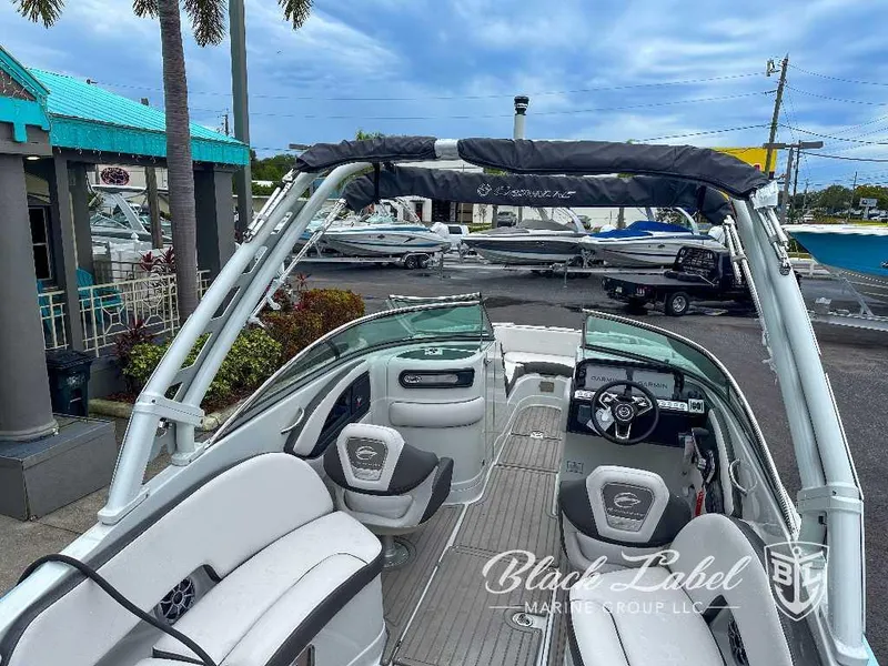 Slide: The Image of 2024 Crownline E280 XS boat interior with helm and seating, displayed at a marina. - 8
