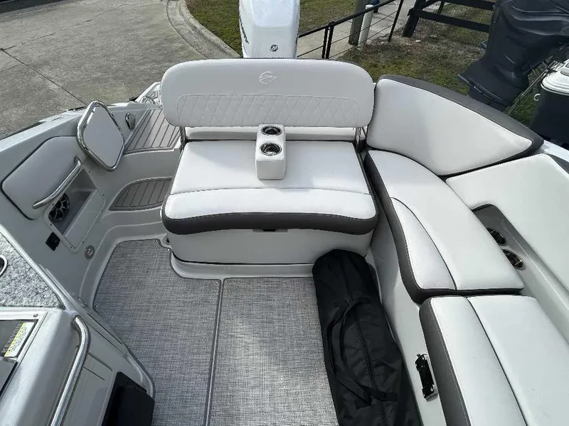 Slide: The Image of 2024 Crownline E280 XS boat interior with white cushioned seating and cup holders. - 10